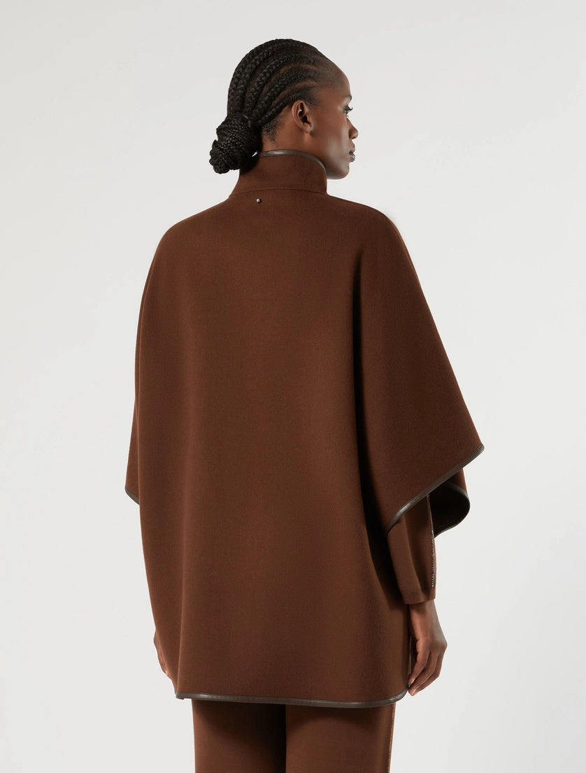 Biscuit cape with stand collar and button back, faux leather trim on hems