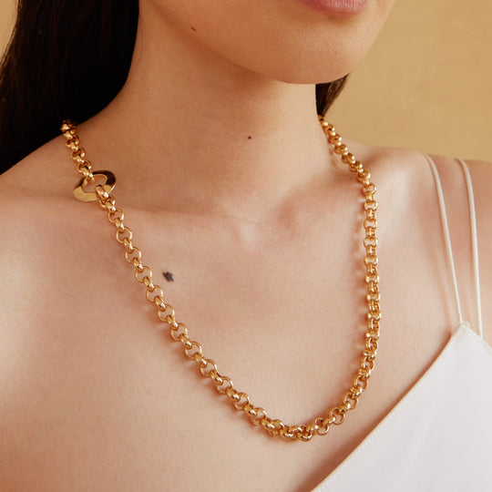 Gold chain link necklace worn by model, showing convertible lariat style with decorative clasp