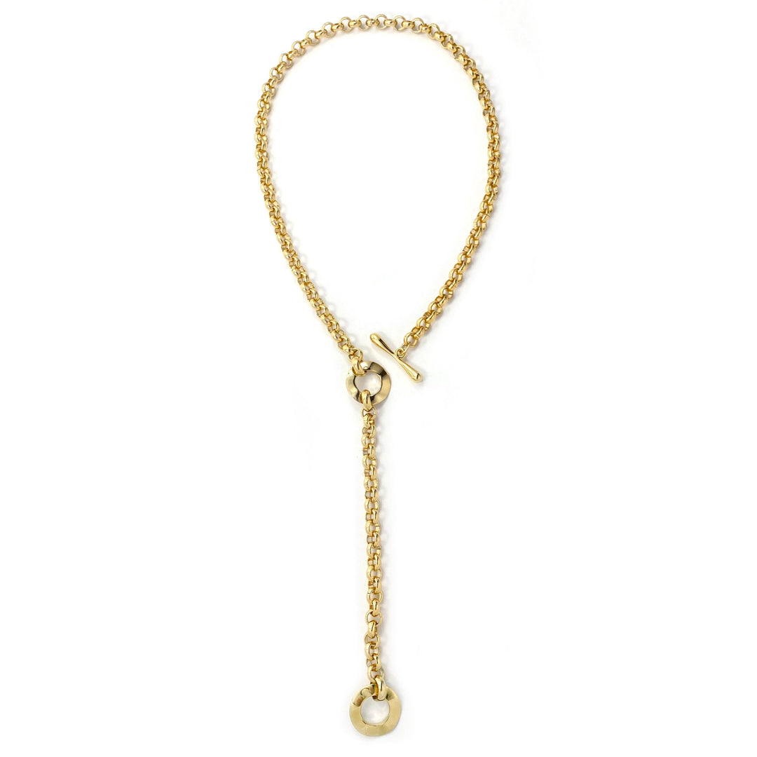Gold chain lariat necklace with toggle clasp and circular pendant, laid flat overhead view