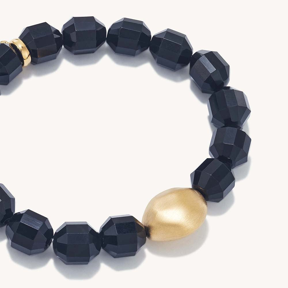 Black faceted bead bracelet with gold teardrop centerpiece and clasp
