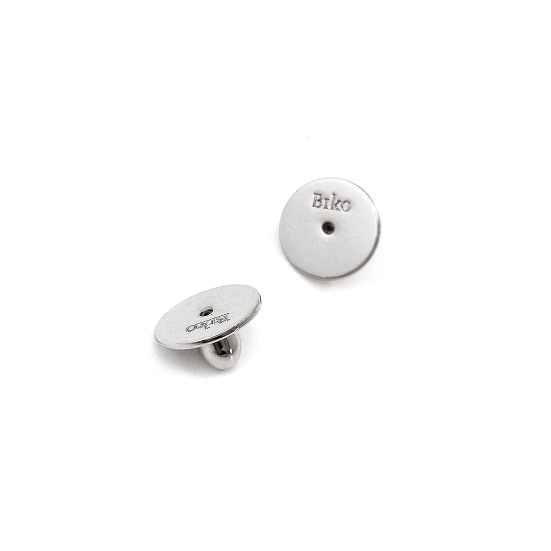 Silver circular disc stud earrings with small hole detail, one showing front view and one showing side profile