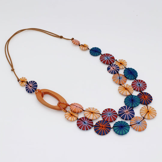 Multi-strand necklace with colorful circular disc beads in warm earth tones on leather cord