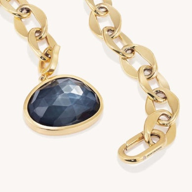 Gold-tone collar necklace with faceted dark-blue oval stone pendant