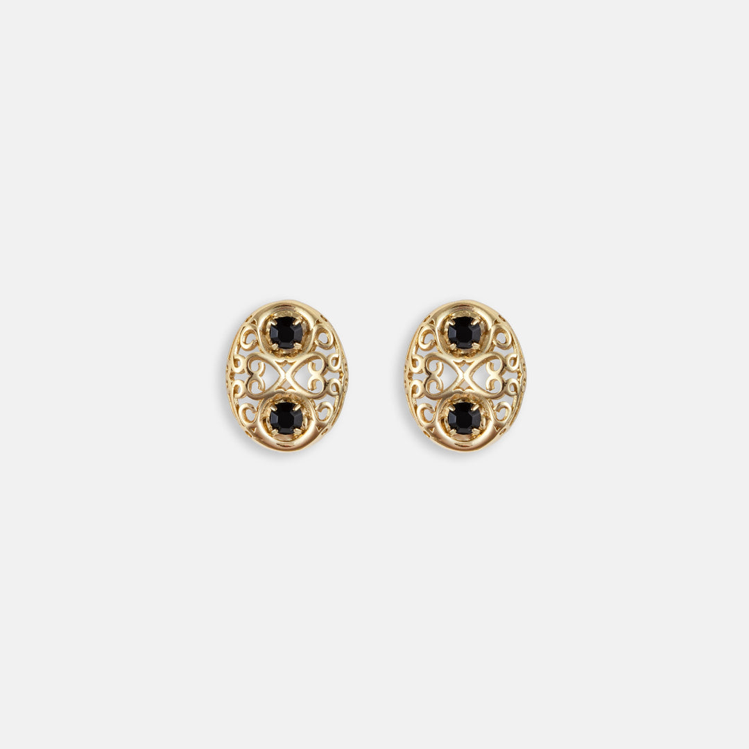 Oval gold filigree stud earrings with two black gemstones and intricate scrollwork design
