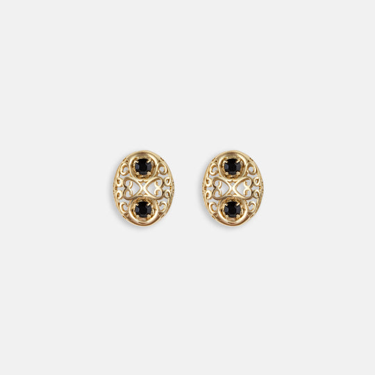 Oval gold filigree stud earrings with two black gemstones and intricate scrollwork design
