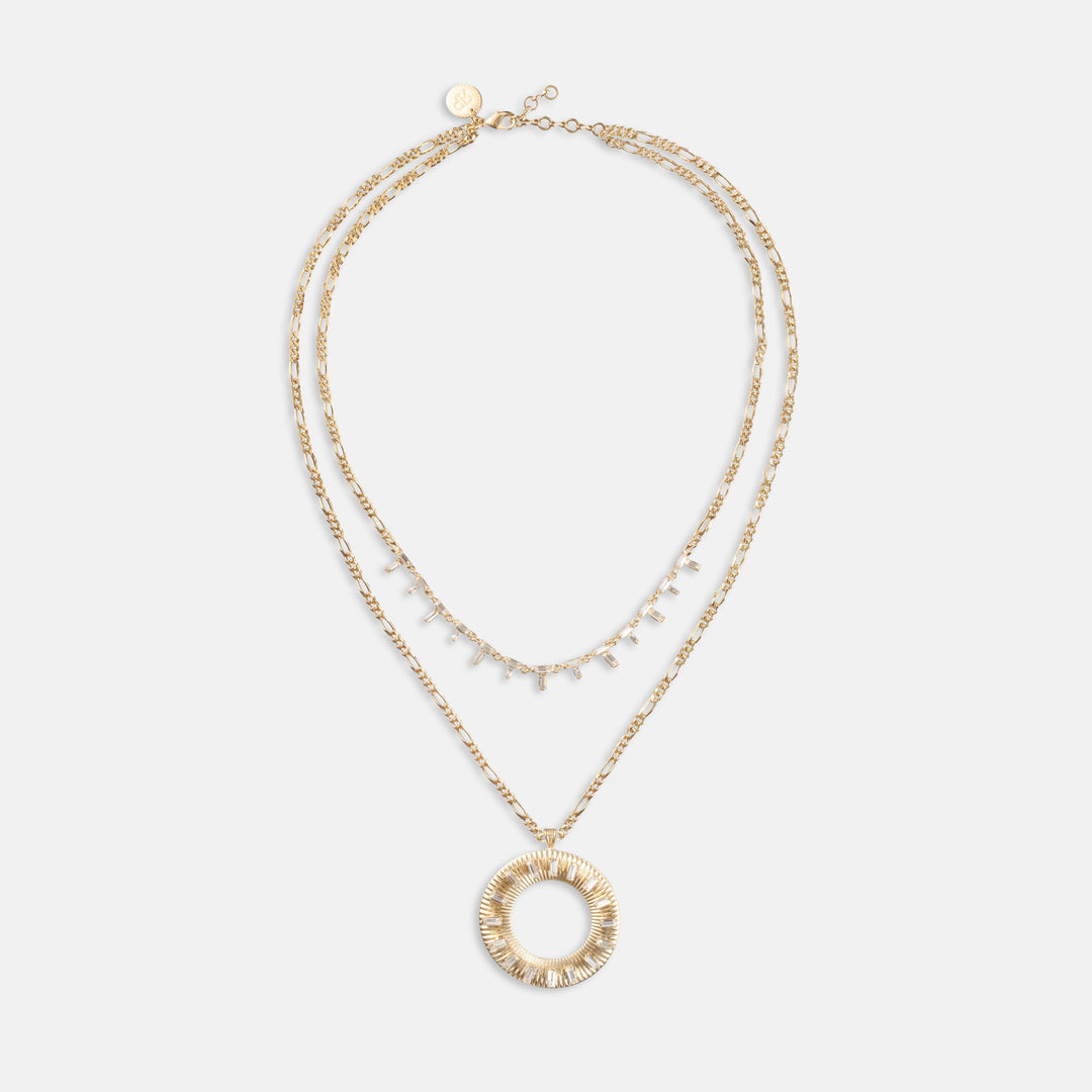Layered gold necklace set with crystal baguette strand and large circular sunburst pendant