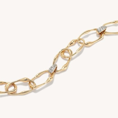 Gold link bracelet close-up with white CZ stones on oval links