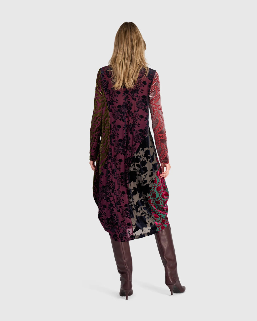 Burnout velvet mixed-print dress shown from back with long sleeves and asymmetric drape.