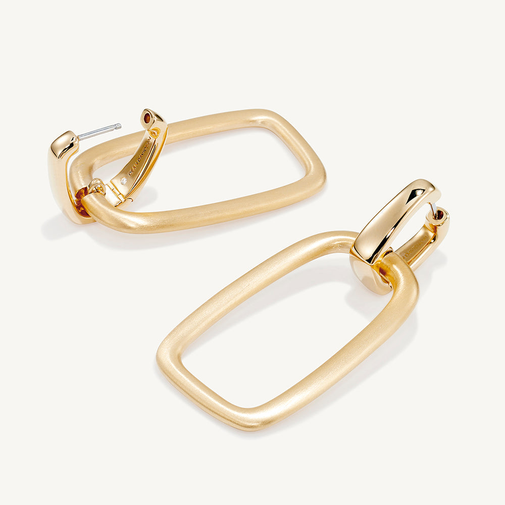 Pair of gold rectangular drop hoop earrings with brushed matte finish and polished connector, shown from slight angle