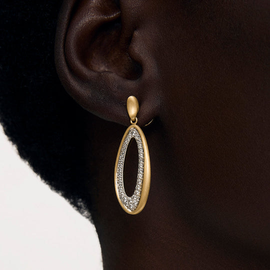 Oval drop earring with matte gold frame and pavé crystal interior, shown on model's ear
