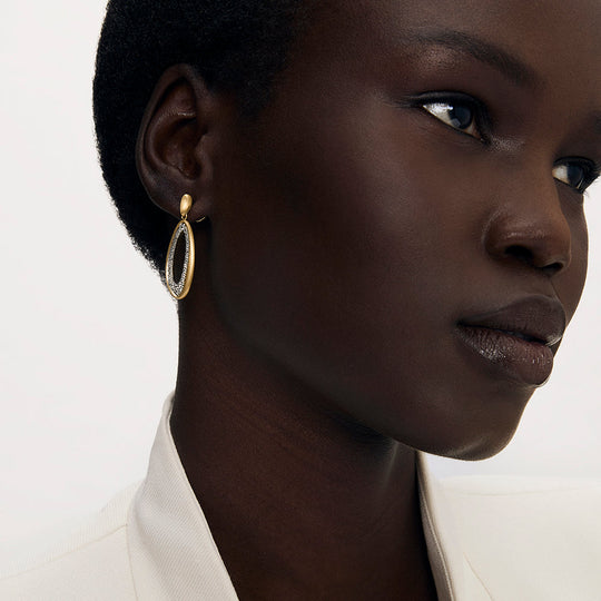 Oval drop earring with gold frame and crystal pavé detail, worn on model's ear