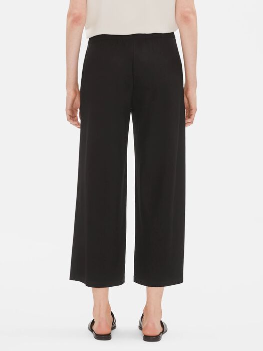 Black wide-leg cropped pants shown from behind on model with neutral background