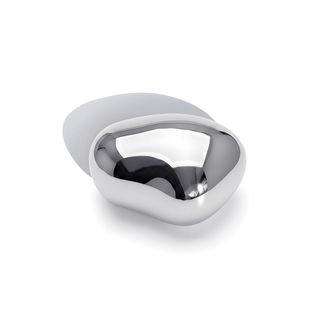 Modern sculptural brooch with curved silver metal design photographed from above