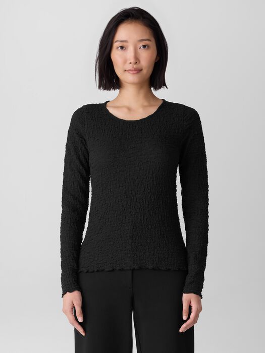 Long-sleeve black textured bubble jacquard top with round neckline, front view on model