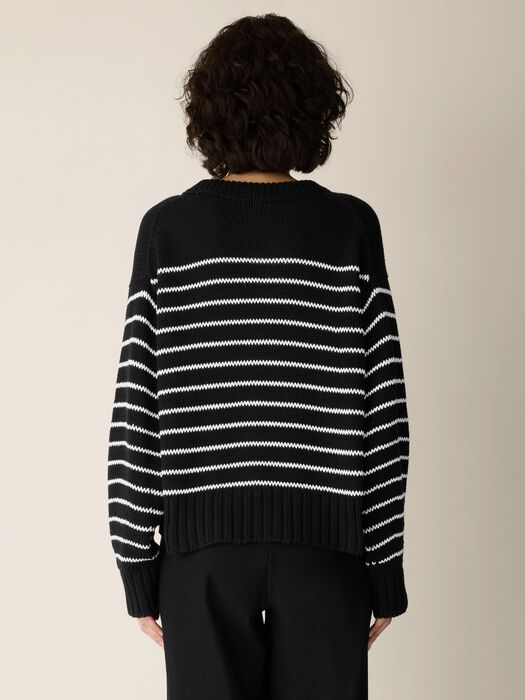 Black sweater back with white horizontal cord stripes and ribbed band hem.