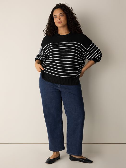 Black sweater with white horizontal stripes, crew neck, ribbed cuffs.