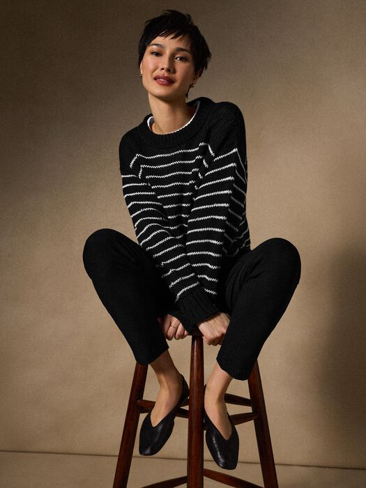 Black sweater with white stripe knit, crew neck and ribbed cuffs.
