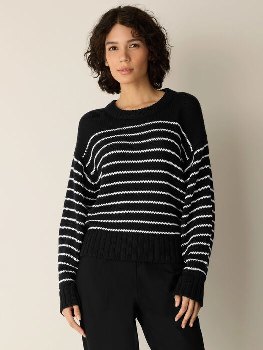 Black sweater with white horizontal cord stripes, crew neck, long sleeves.
