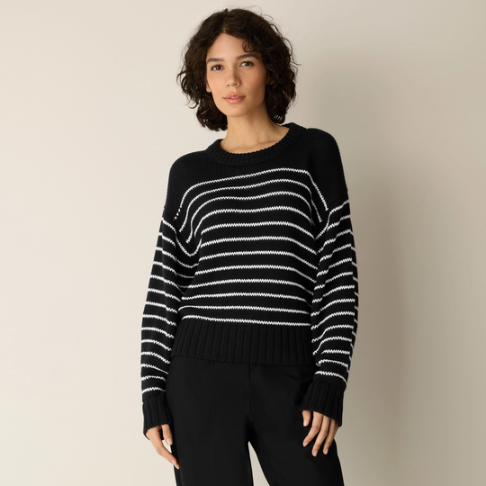 Black crewneck sweater with white cord stripes, long sleeves, ribbed hem.
