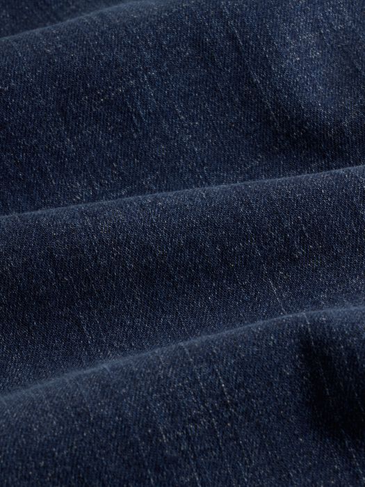 Close-up detail of dark indigo denim fabric showing texture and weave