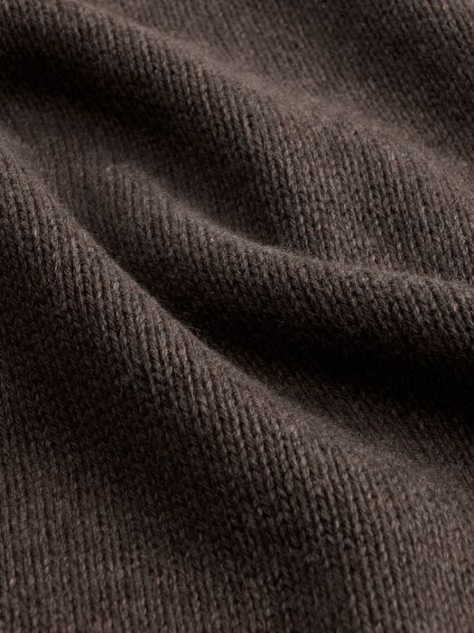 Close-up fabric detail of a dark brown-gray knit sweater showing texture and weave