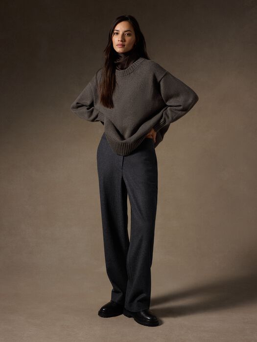 Oversized crew neck knit sweater in warm gray-brown, full-length model view with wide-leg trousers