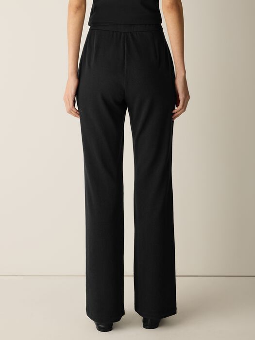 Black wide-leg kick pants with elastic waistband, rear view on model