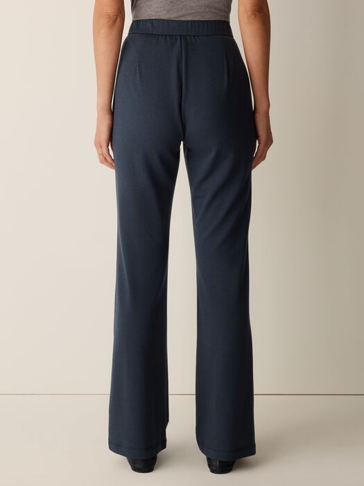 Wide-leg navy pants with elastic waistband, back view on model, full length