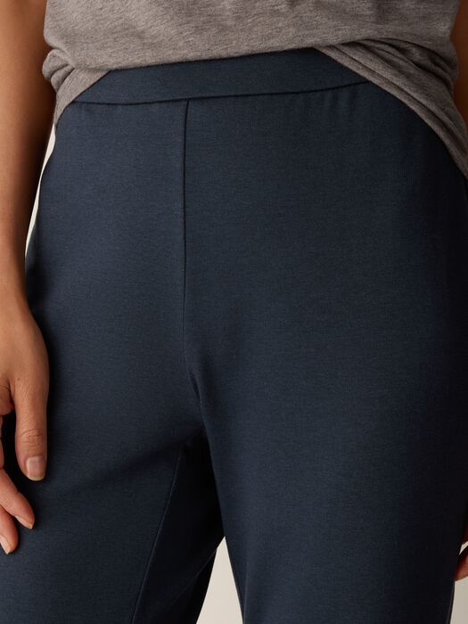 Close-up of dark navy pull-on kick pants with elastic waistband, worn by model