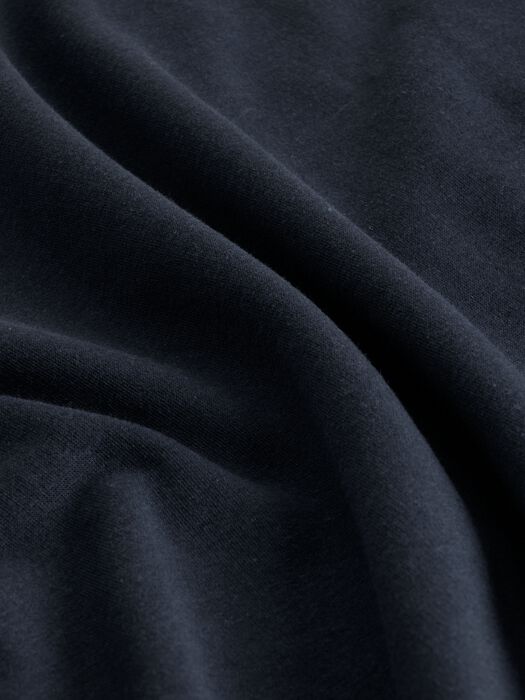 Close-up of dark navy brushed terry fabric showing soft texture and drape