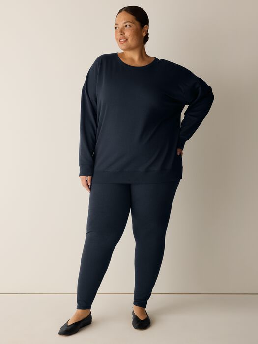 Dark navy long-sleeve crew neck sweatshirt with relaxed fit, shown on model with matching leggings