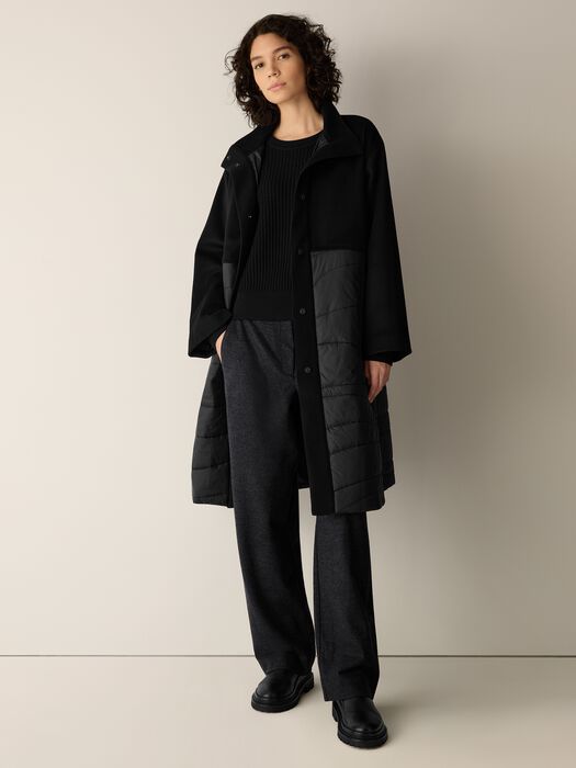 Black stand-collar coat with button front and gray quilted panel detail at sleeves.