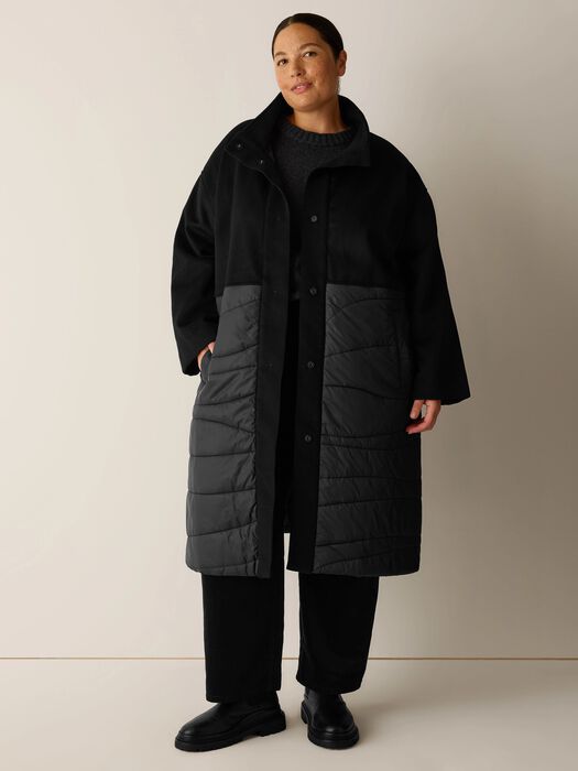 Black stand-collar coat with button closure and gray quilted front panels.