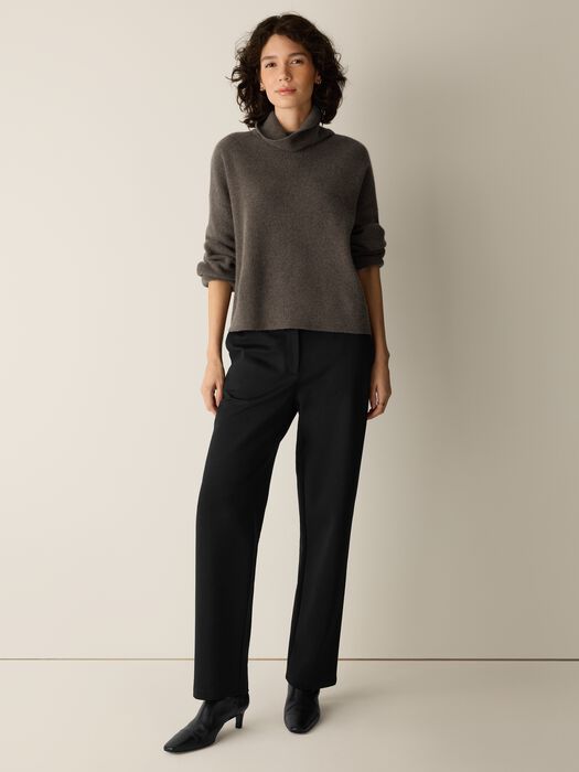 Relaxed-fit turtleneck sweater in heathered gray-brown, long sleeves, worn with black trousers, front view