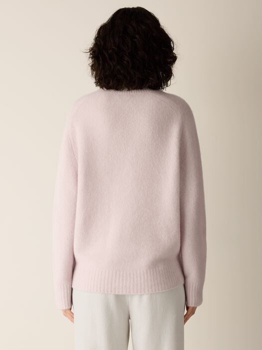 Light mauve V-neck sweater, relaxed back with ribbed hem.