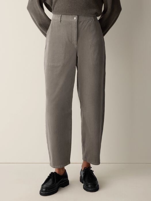 Relaxed taupe ankle pants with front patch pockets and barrel-leg silhouette, styled with black loafers