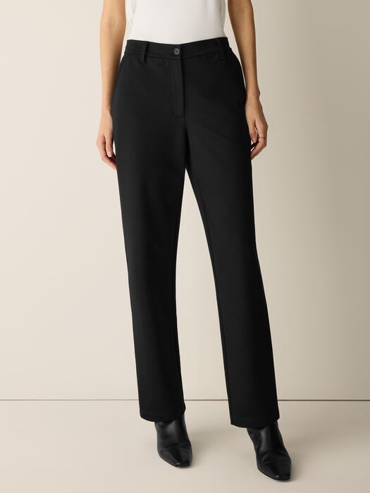High-waisted straight-leg black trousers with button closure, worn by model, front view