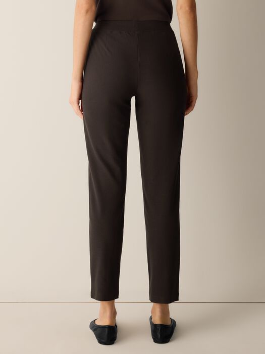 Slim-fit dark brown stretch crepe pants shown from the back on a model, ankle length