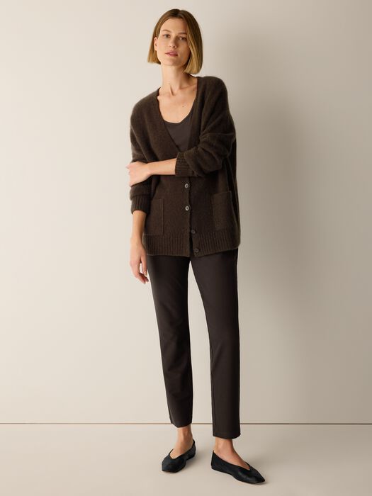 Slim-fit dark brown tapered trousers worn by a model with flat shoes, front view