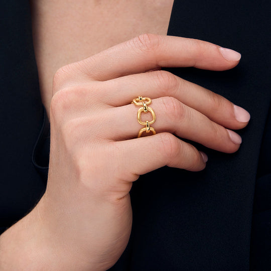Gold chain-link ring on finger with chunky interlocking links