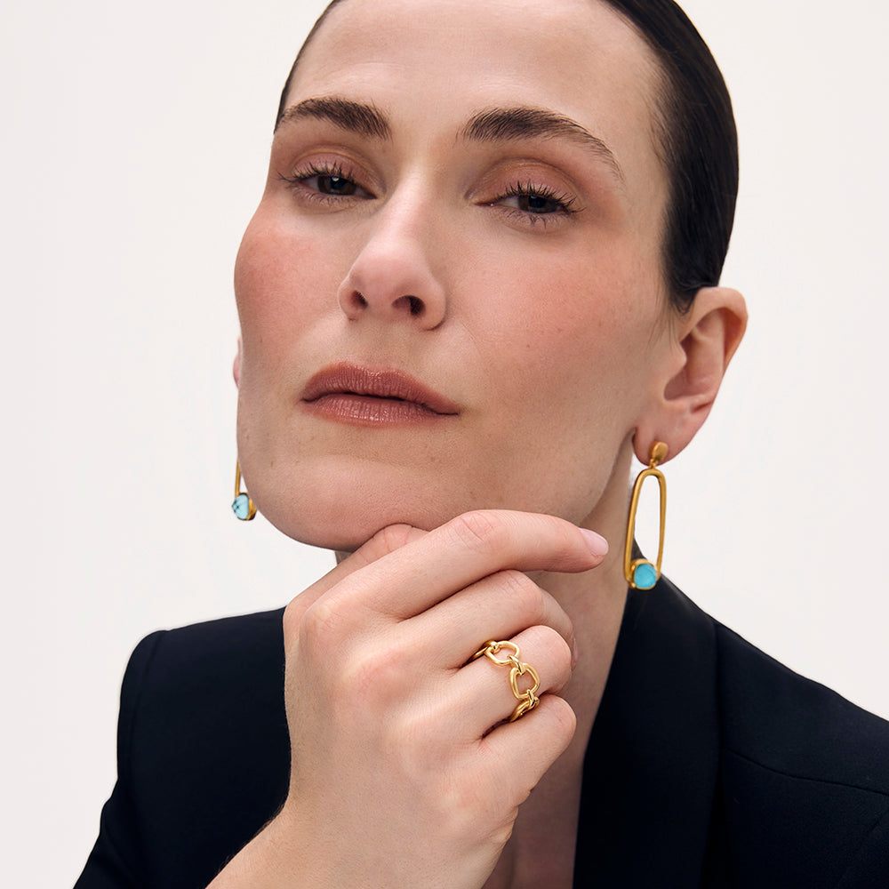 Gold chain-link ring worn on finger, chunky interlocking links