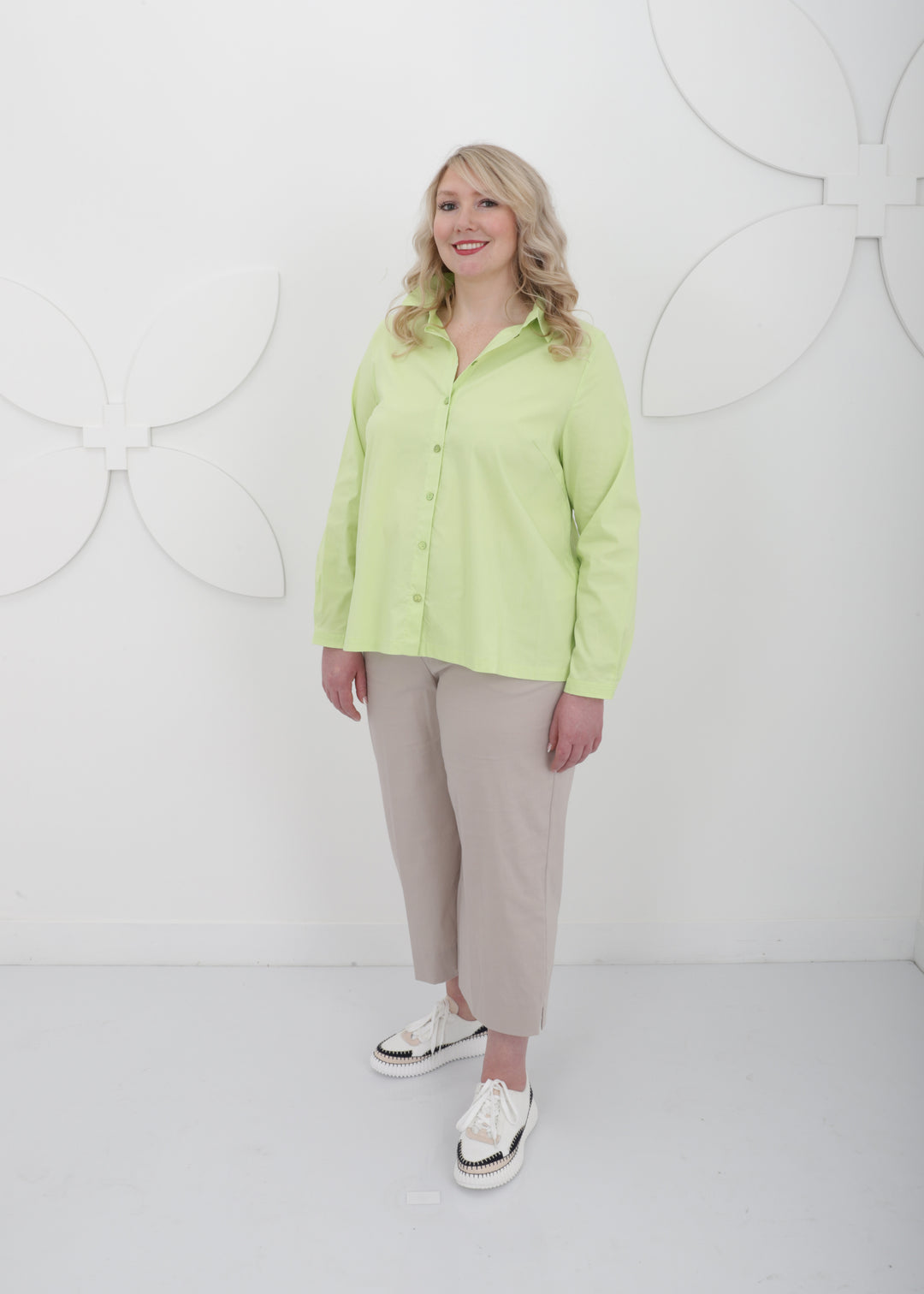 Front view of Toni T. plus size long sleeve A-line shirt in stretch poplin, bamboo green color on model with linen ankle pant