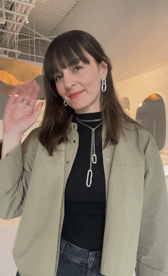 Layered chain lariat necklace with oval links worn by model in black top