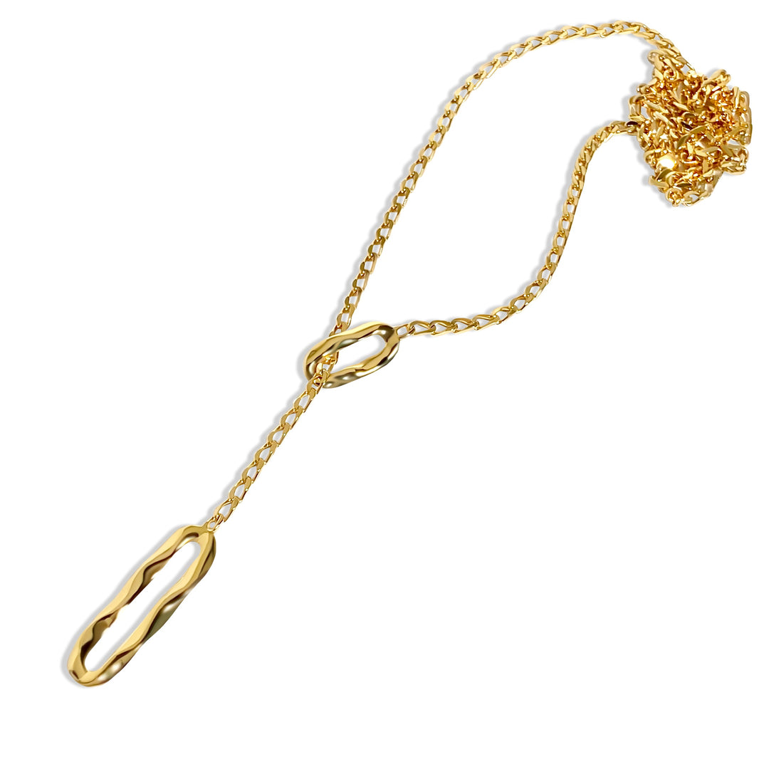 Gold chain lariat necklace with oval links and elongated pendant, displayed on white background