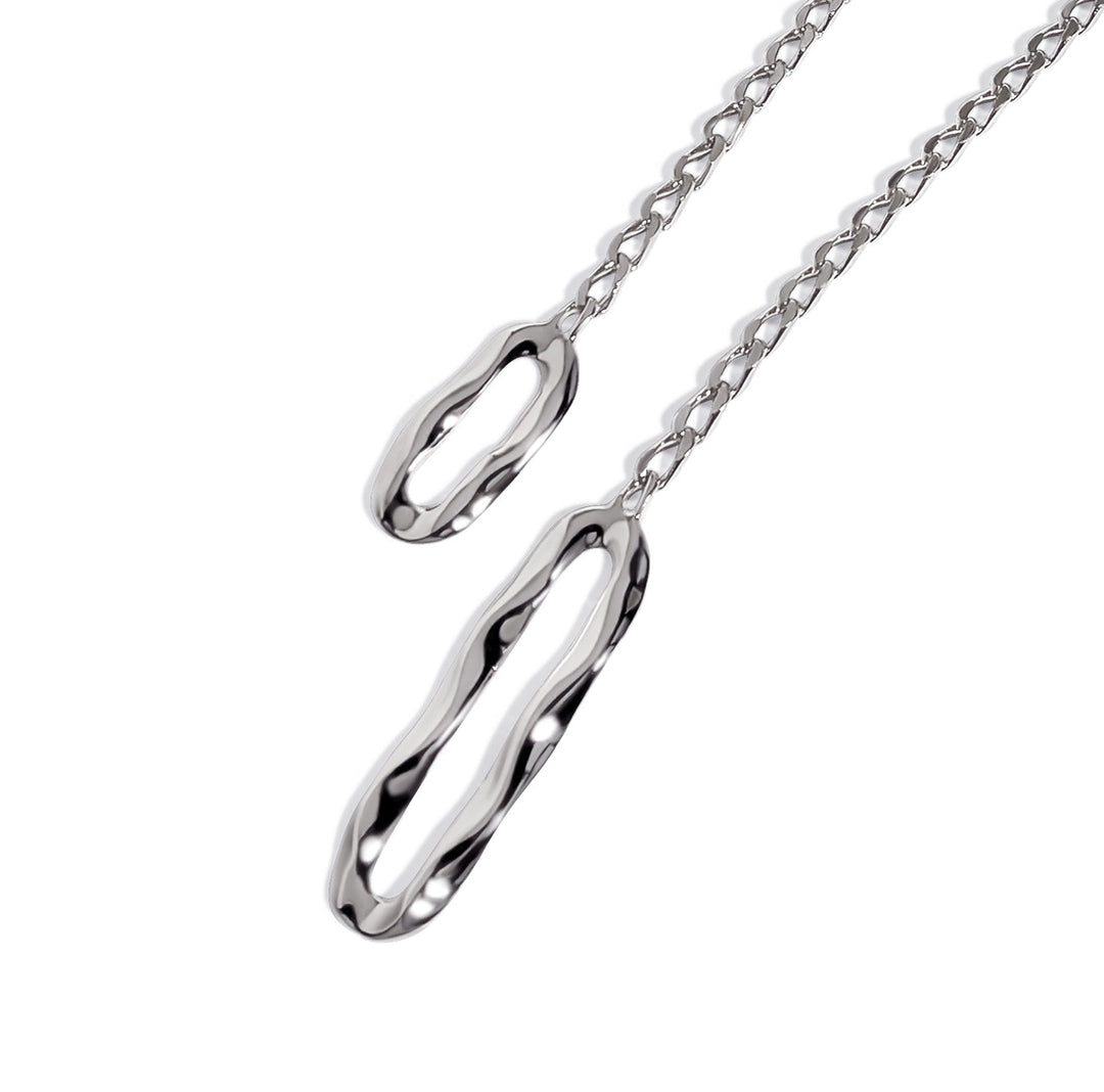 Lariat necklace with two elongated oval pendants on chain links against white background