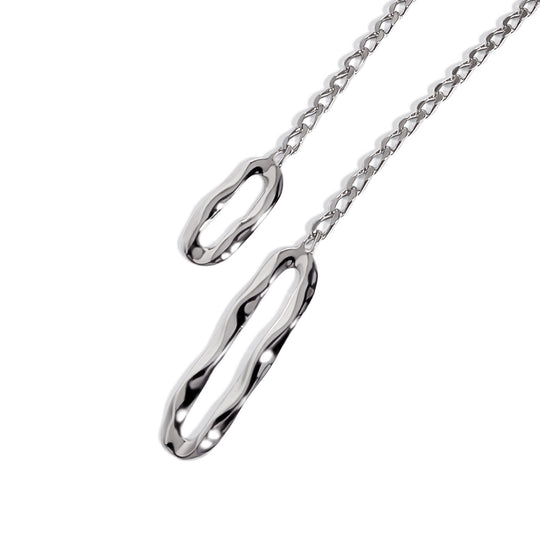 Lariat necklace with two elongated oval pendants on chain links against white background