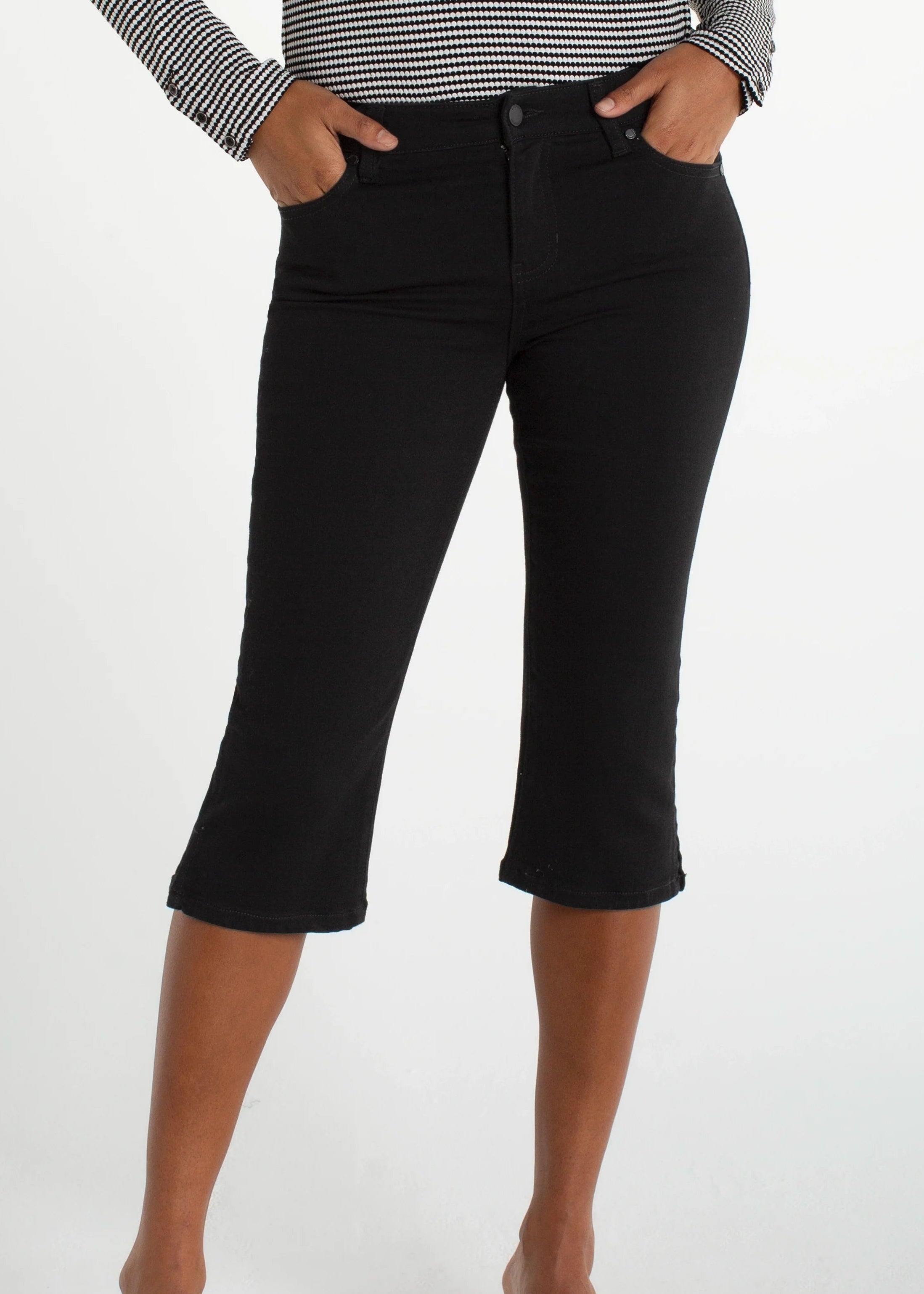 Person wearing black capri pants on a white background