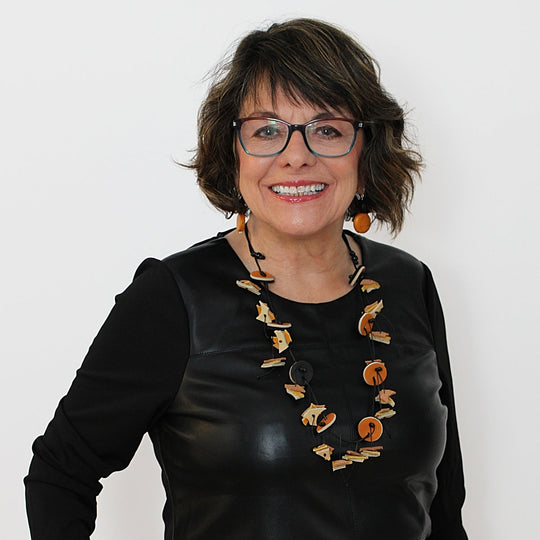 Statement necklace with geometric yellow and brown circular elements worn by model