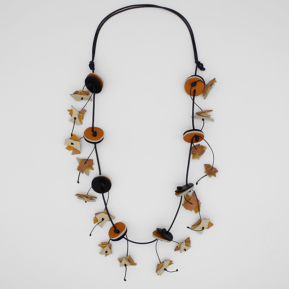 Long beaded necklace with circular discs and decorative leaf-like elements on adjustable cord