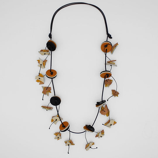 Long beaded necklace with circular discs and decorative leaf-like elements on adjustable cord